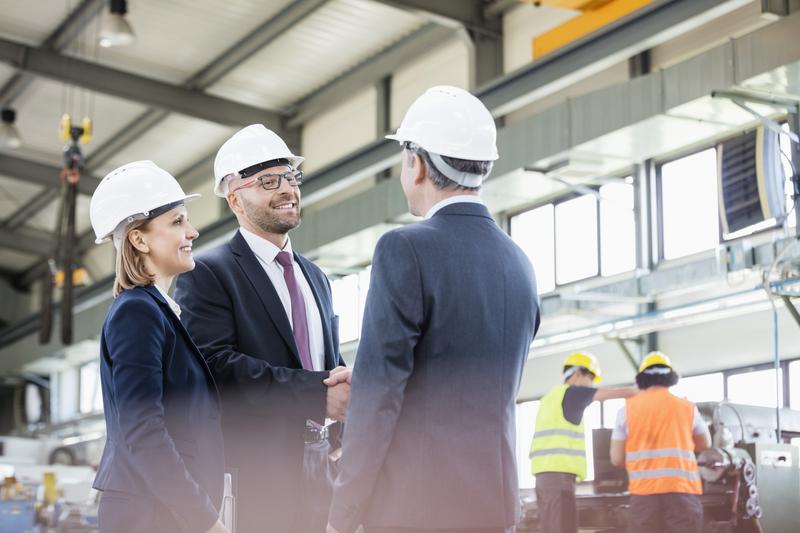 Belden industrial networking experts meeting with operations team on factory floor connectivity solutions.