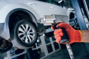 Manufacturing employee holds smart tool on car assembly line