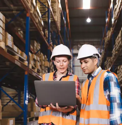 Logistic worker staff colleague in safety suit holding computer laptop working in warehouse store
