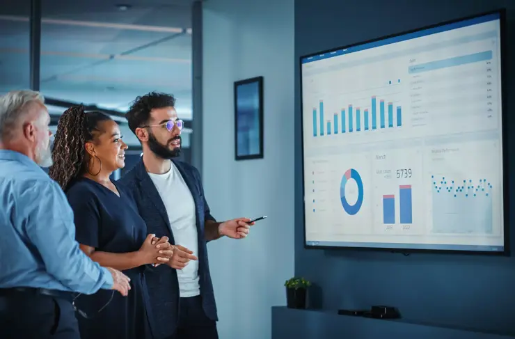 Le directeur des opérations de l’entreprise effectue une présentation de réunion. Diverses équipes utilisent un écran de télévision avec analyse de croissance, graphiques, statistiques et données. Les gens travaillent dans un bureau d’affaires.