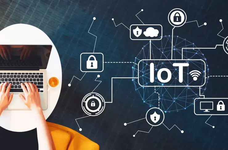 IoT security theme with person using a laptop on a white table