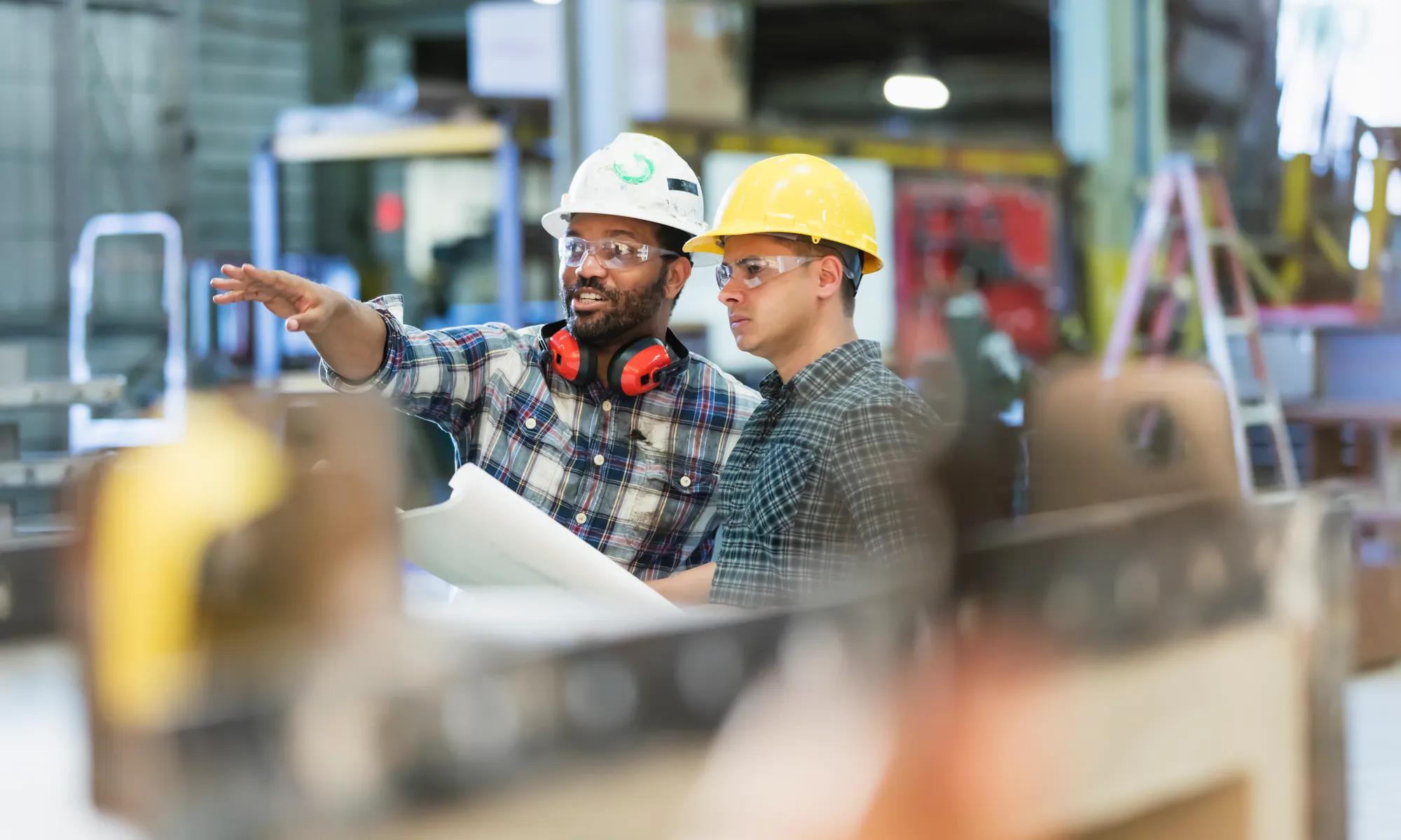 Multi-ethnic workers talking in metal fabrication plant