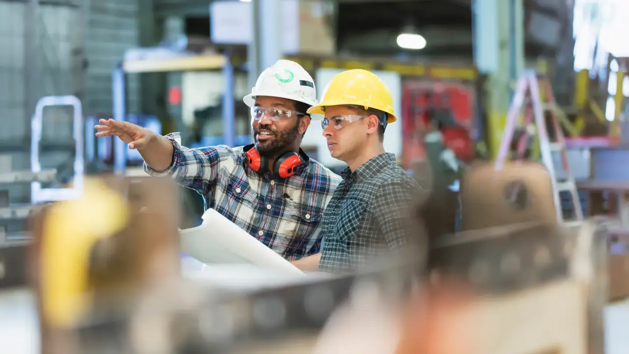 multi-ethnic workers talking in metal fabrication plant
