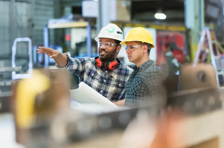 multi-ethnic workers talking in metal fabrication plant