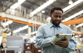 Increase Machine Efficiency with Asset Performance Management in Manufacturing Industry. A Male Production Control Manager using a digital tablet in the production line to remote asset monitoring , asset health for reduce production downtime and predictive maintenance.