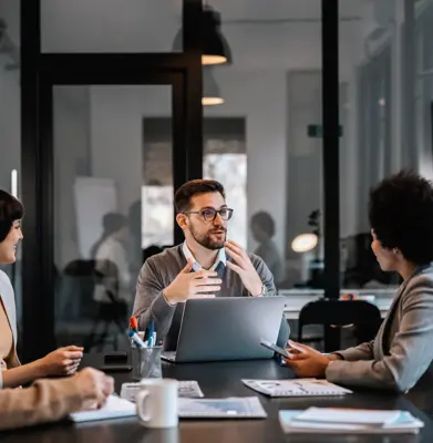 A dedicated mentor is explaining mentees importance of project while sitting at the boardroom in corporate firm.