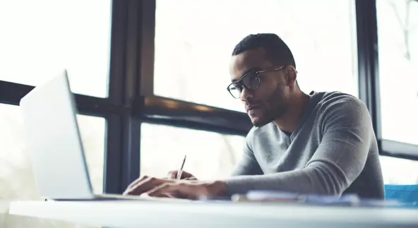 skilled afro american male it professional freelancer working on clients project updating software improving code of application working in coffee shop using laptop computer and wireless internet