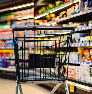un chariot près d’une étagère de magasin dans un supermarché