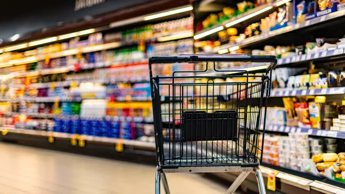 un chariot près d’une étagère de magasin dans un supermarché