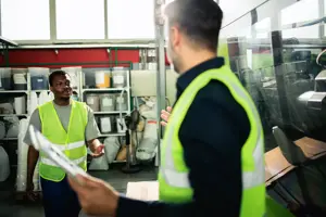 zwei Bediener aus dem Werk, die die Geräte handhaben