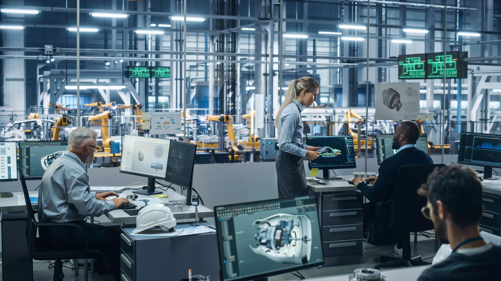 Car Factory : Équipe d’ingénieurs automobiles travaillant à l’aide d’ordinateurs pour concevoir des modèles 3D avancés pour les moteurs de haute technologie. Bras robotique automatisé Chaîne de montage industrielle Fabrication de véhicules électriques