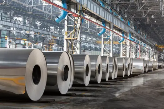 row of rolls of aluminum lie in production shop of plant.