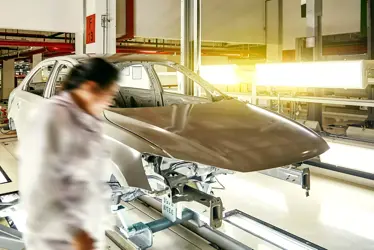 on the assembly line of the automobile manufacturing plant, workers are checking the body