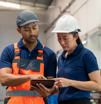 Warehouse worker and manager checks stock and inventory with digital tablet.
