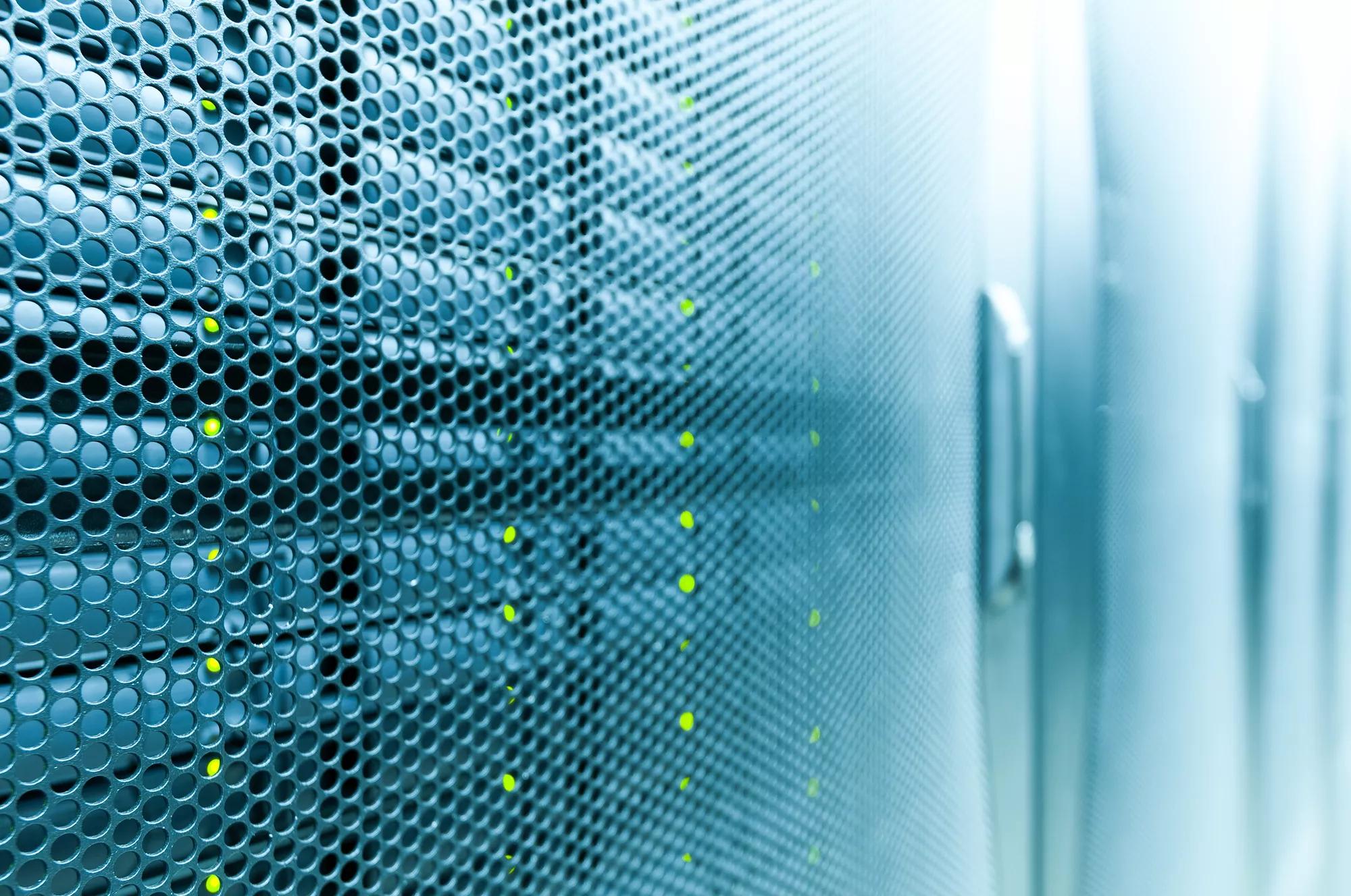 High tech internet data center room with rows of racks with network and server hardware.