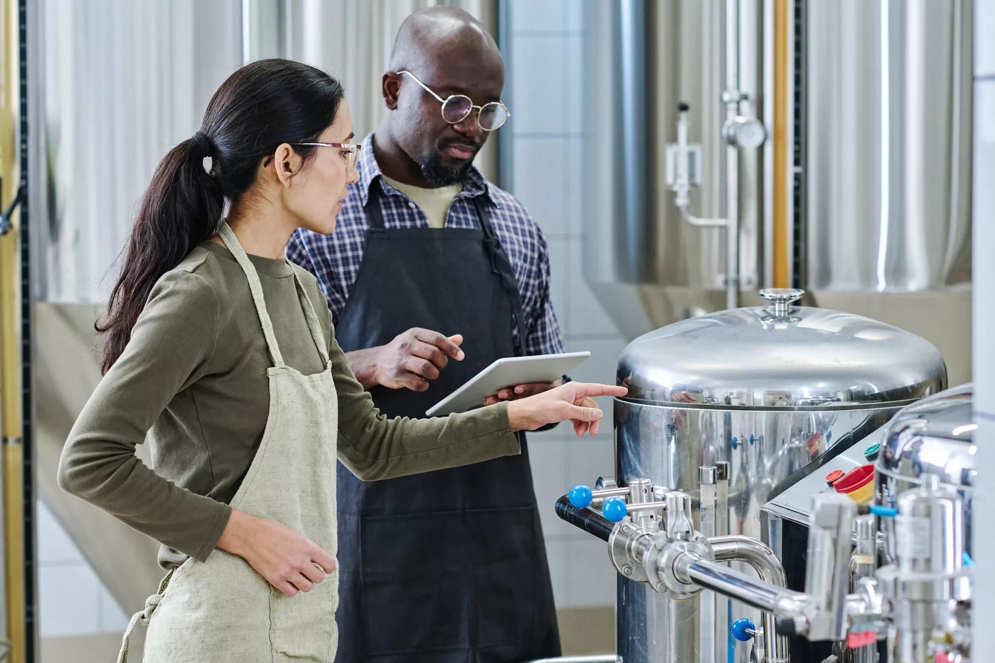 Couple of engineers examining equipment at plant