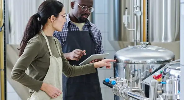 Couple of engineers examining equipment at plant