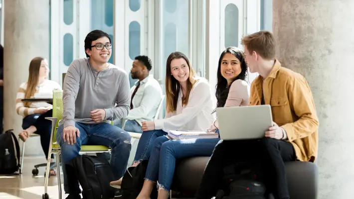 A group of college students gather in common area