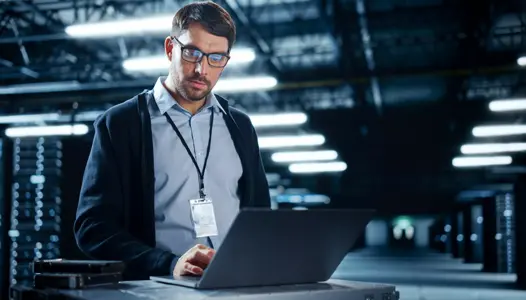 successful data center it specialist using laptop computer. server farm cloud computing facility with system administrator working. data protection engineering network for cyber security.