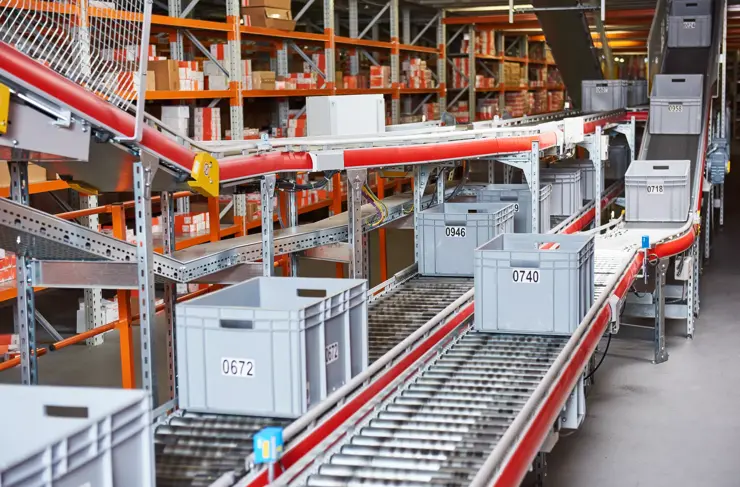 Entrepôt automatisé. Boîtes avec pièces de rechange circulant sur convoyeur