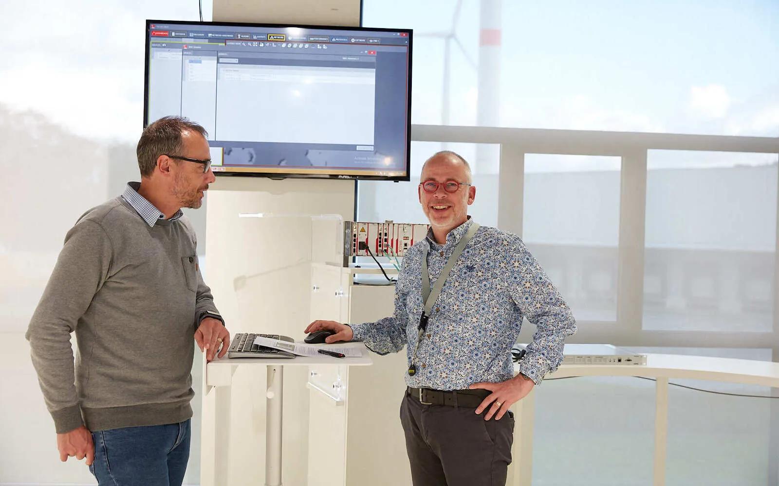 Two OTN technicans standing before a computer