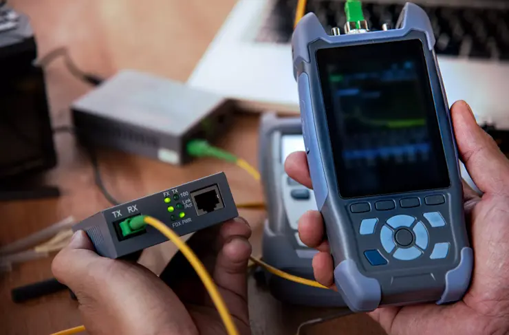 mains de maître avec testeur de fibre optique après Fusi, compteur OTDR
