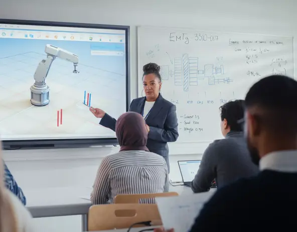 female professor standing next to interactive whiteboard and teaching diverse students innovations in robotics. computer science and modern technologies in higher education concept.