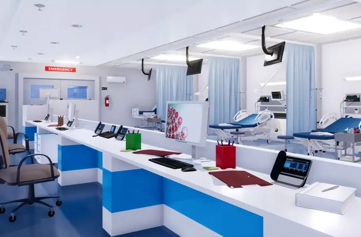 Emergency room beds outfitted with telemetry devices with nurses' station in foreground