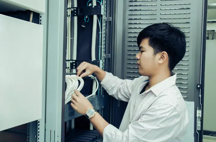 Asian Technician man checking LAN wire with receiver hub of control room, vintage tone 