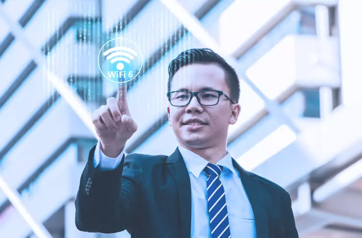 Wifi 6 internet network communication concept with Young businessman standing and point to button Wifi 6 with cityscape background.
