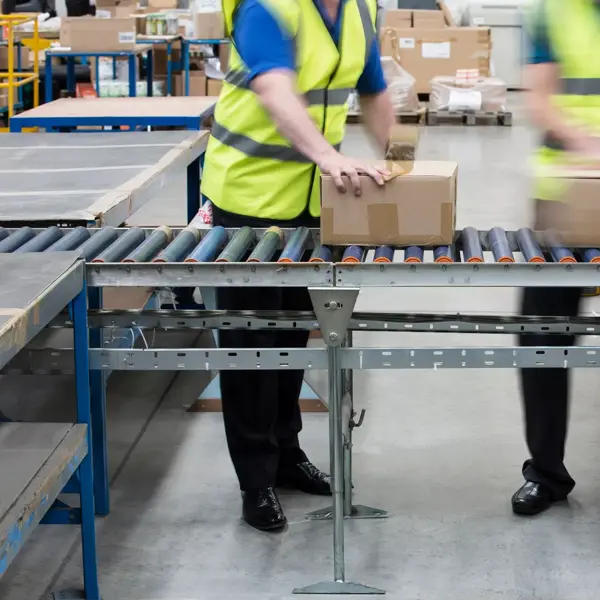 Men passing cardboard boxes along conveyor belt