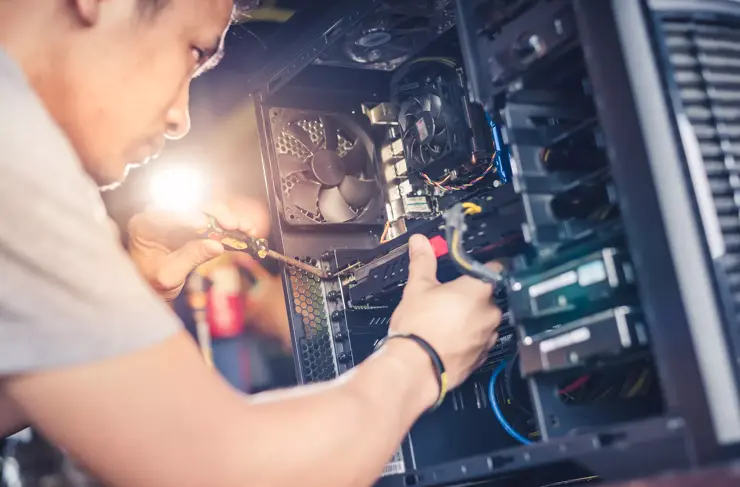 Le technicien tient un tournevis pour réparer l’ordinateur. Concept de matériel informatique, de réparation, de mise à niveau et de technologie.