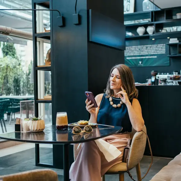 Une femme d'affaires utilise son téléphone portable dans un café d'hôtel.