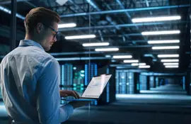 Back View of Male Specialist Using Laptop in Big Data Center Office. High Speed Data Transfer, Server Transfer, Technology Science Breakethrough, Progress, Innovation Concept