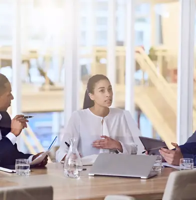Gruppe von vier Unternehmern mit dynamischer Erfahrung und vielseitigem Hintergrund, die alle damit beschäftigt sind, zusammenzuarbeiten und während eines geplanten wöchentlichen Treffens miteinander zu sprechen.