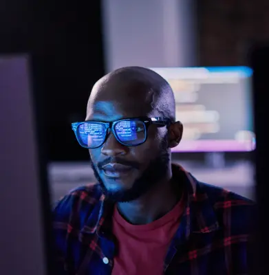 Cyber security, black man and code reflection in eyewear, hacking and software update in office. African American male employee, programmer or IT specialist with glasses, focus and cloud computing