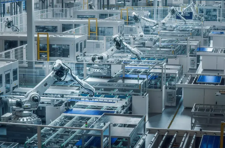 Grande ligne de production avec bras robotiques industriels blancs dans une usine moderne et lumineuse. Des panneaux solaires sont assemblés sur un convoyeur. Usine de production automatisée.