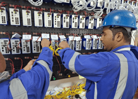 man with blue hard hat working on switches - customer image for ZMS Qatar Case Study