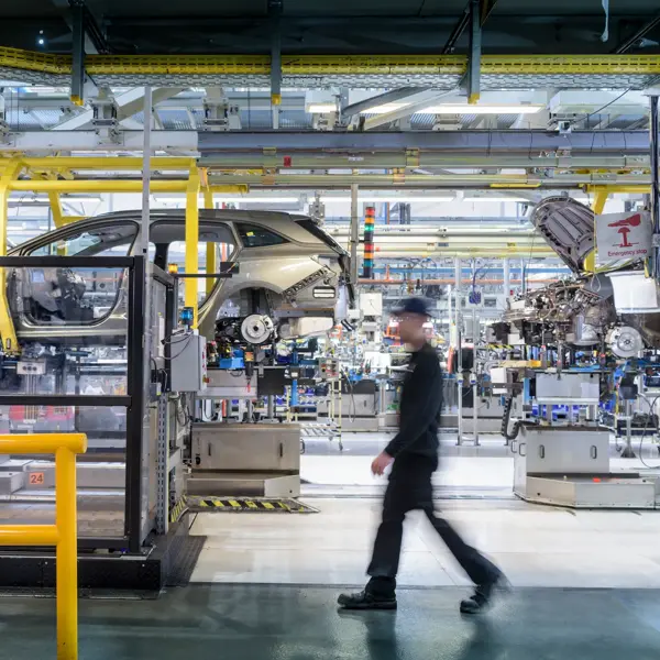 Engineer walking past car production line in car factory