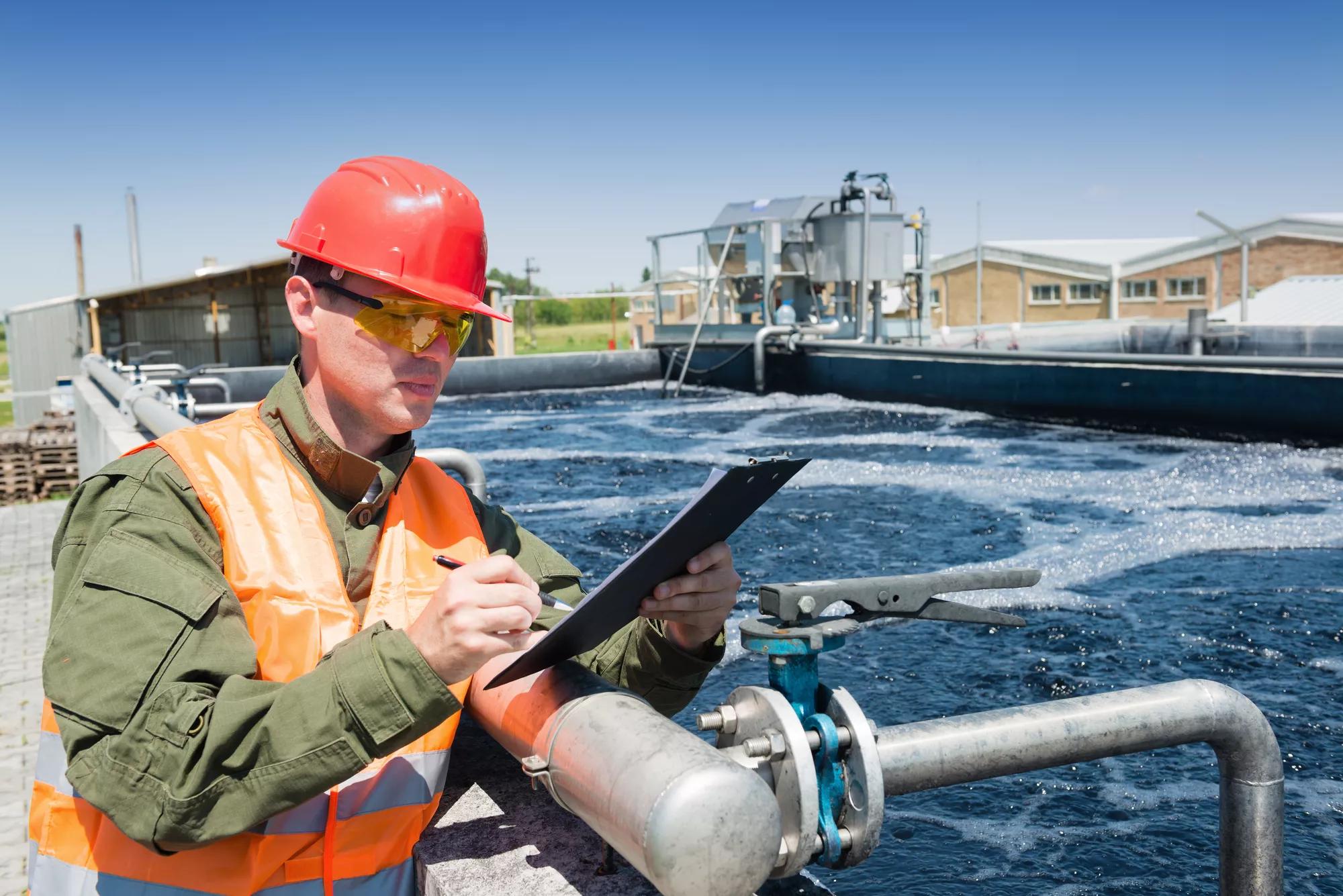 An engineer controlling the quality of water , aerated activated sludge tank at a waste water treatment plant